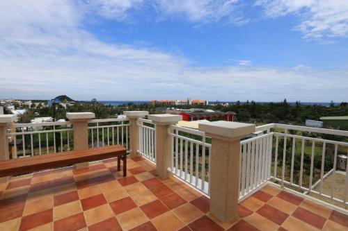 a balcony with a bench and a view of the city at Island on the Sea in Kenting