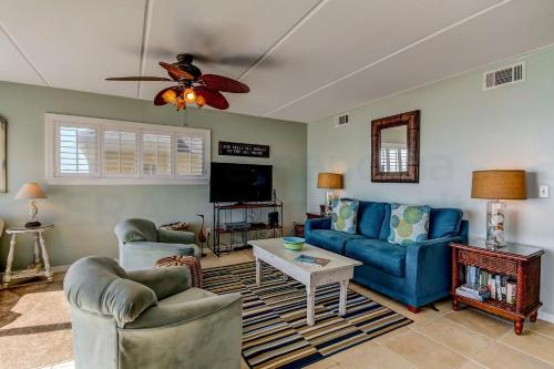 a living room with blue couches and a tv at Oceans Of Amelia - 315 Condo in Fernandina Beach