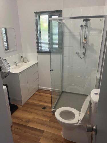 a bathroom with a shower and a toilet and a sink at Bungalow 32 at Lake Bennett 2 Brm home in Lake Bennett