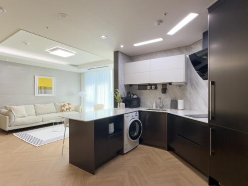 a kitchen and living room with a washer and dryer at Brown Suites Busan Station in Busan