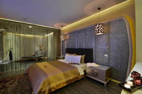 a hotel room with a large bed and a bathroom at Xiadu Motel in Taichung