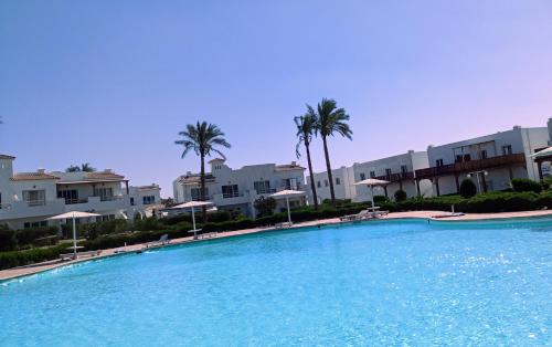 a large swimming pool with palm trees and buildings at Naama wiew- Alle due palme in Sharm El Sheikh