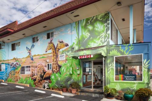 een gebouw met een muurschildering van giraffen erop bij Aqua Breeze Inn in Santa Cruz
