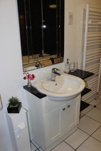 a bathroom with a white sink and a mirror at Bitacora in Waternish