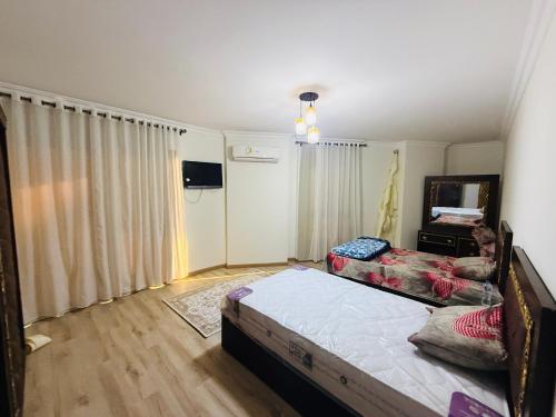 a bedroom with a bed and a tv in it at شقة للايجار in Alexandria