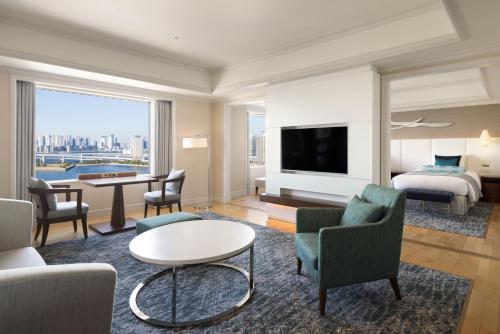 a hotel room with a bed and a living room at Grand Nikko Tokyo Daiba in Tokyo