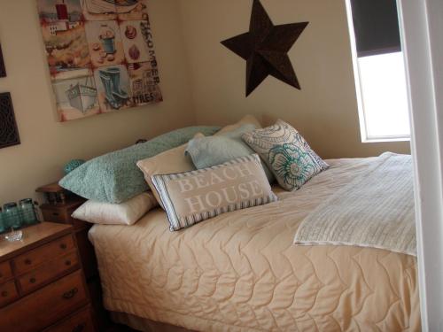 ein Schlafzimmer mit einem Bett mit Kissen und einem Stern an der Wand in der Unterkunft Belmont Shore Beach House in Belmont Shore