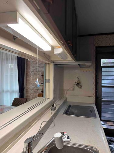 a kitchen with a sink and a counter top at 2 Double bed and 1 Sofa bed Fullsize bathroom Shinjuku 20 minutes Quiet cozy room Walmart DonDonDonk Station 7 minutes Free parking at Tanashi Station in Nishitokyo