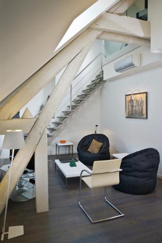 a living room with two chairs and a staircase at Maison d'Hôte de Myon in Nancy