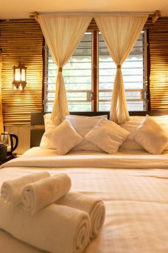 a bedroom with a large bed with towels on it at Monraumsuk home stay Chiang Mai in Ban Pok Nai