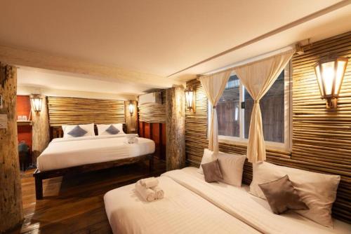 a hotel room with two beds and a window at Monraumsuk home stay Chiang Mai in Ban Pok Nai