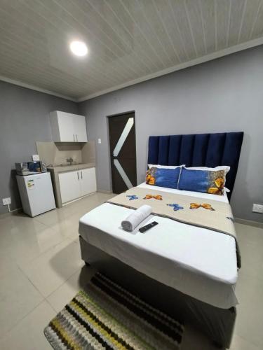 a bedroom with a large bed with a blue headboard at Gift Guest house 1 in Cravenby