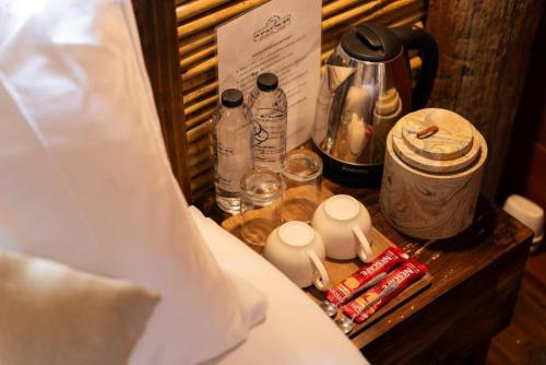 a nightstand with a coffee maker and a tea kettle at Monraumsuk home stay Chiang Mai in Ban Pok Nai