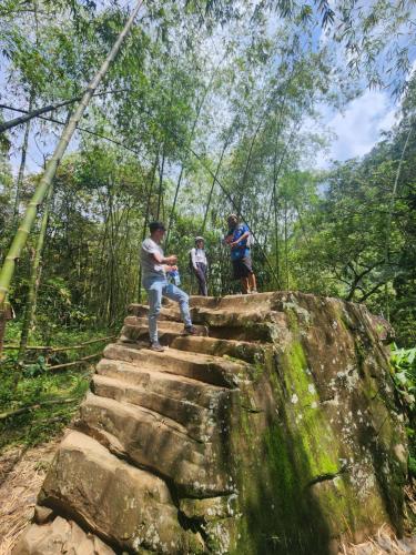 a group of people sitting on a rock in the forest at Finca la India Cerro Tusa in Tarso
