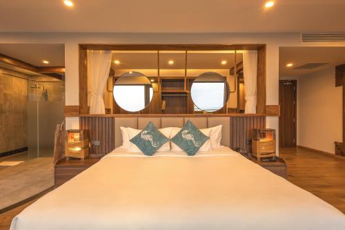 a bedroom with a large white bed with two mirrors at Sunset Beach Resort and Spa in Phu Quoc