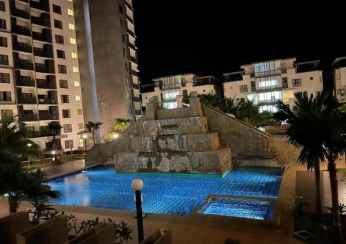 a swimming pool in the middle of a city at night at Nature Home - Swiss Garden Resort Residences in Kuantan