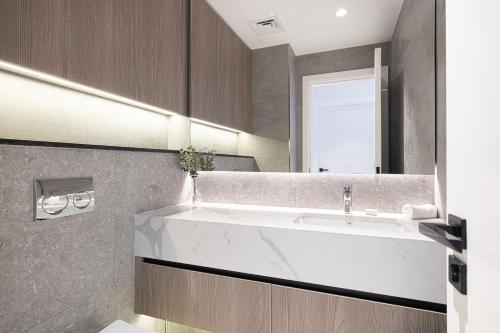 a bathroom with a sink and a mirror at Legacy by Sunrise - Top Amenities and Paddle Court in Dubai