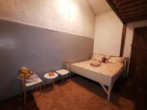 a small bedroom with a bed and a table at Rosie's Beach House El Nido in El Nido