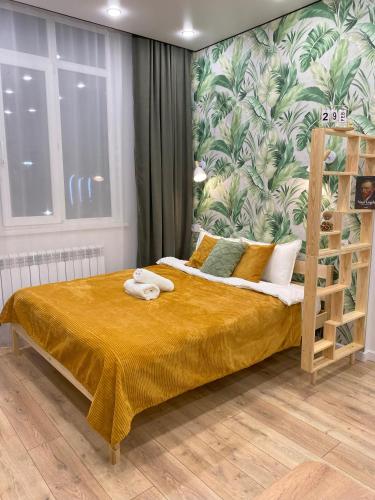 a bedroom with a bed with a tropical wallpaper at Contento Apartments in Almaty