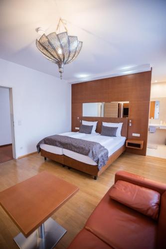 a large bedroom with a bed and a couch at Hotel Stadt Wien in Bad Schallerbach