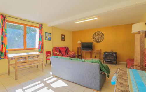 a living room with a couch and a television at Awesome Home In Hucqueliers With Wifi in Hucqueliers