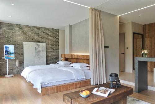 a bedroom with a large bed and a fireplace at Anadu Private House in Huzhou