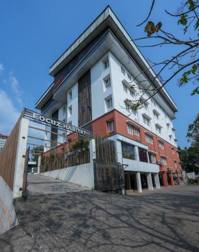 a building with a gate in front of it at Focuz Habitat Hotel And Ayurveda in Malappuram