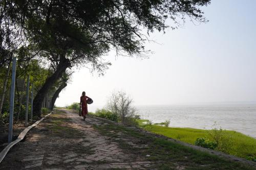 a person walking down a path next to the water at Casa Del Rio in Raichak