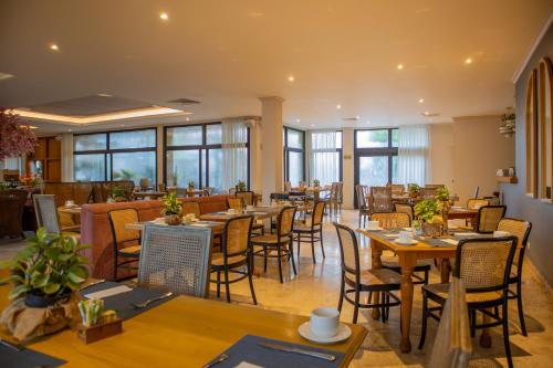 a restaurant with wooden tables and chairs and windows at Hotel Caribe by Faranda Grand, a member of Radisson Individuals in Cartagena de Indias