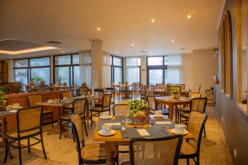 a restaurant with wooden tables and chairs and windows at Hotel Caribe by Faranda Grand, a member of Radisson Individuals in Cartagena de Indias
