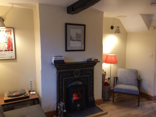 ein Wohnzimmer mit Kamin und Sessel in der Unterkunft Cosy cottage in Snowdonia hamlet in Frongoch