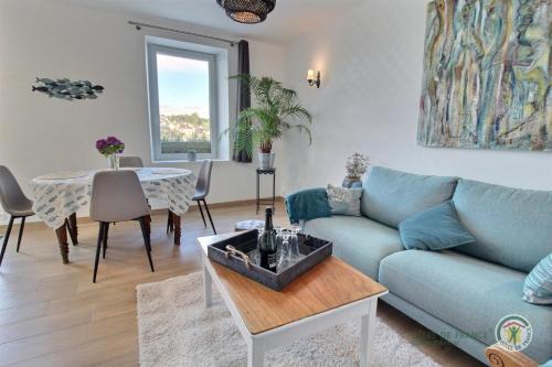 un salon avec un canapé bleu et une table dans l'établissement La maison du pont, à Trédarzec