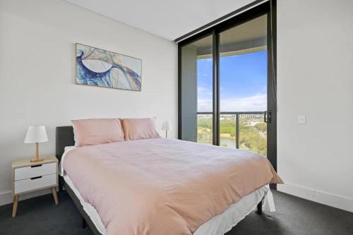 a bedroom with a bed and a large window at 105OP Abnb-Style Spectacular Park View 2BR Apt with Free Parking in Sydney