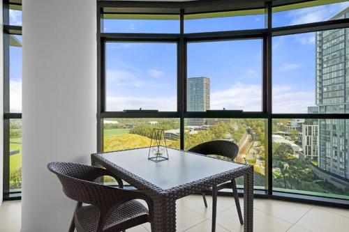 a table and chairs in a room with windows at 105OP Abnb-Style Spectacular Park View 2BR Apt with Free Parking in Sydney