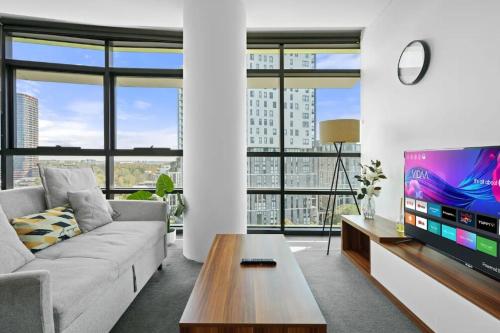 a living room with a couch and a tv at 105OP Abnb-Style Spectacular Park View 2BR Apt with Free Parking in Sydney