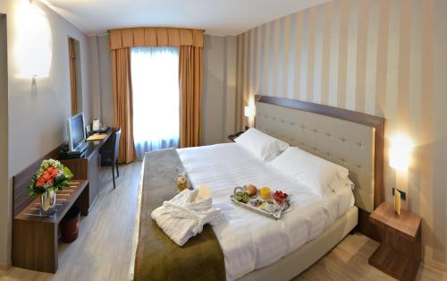 a hotel room with a bed with a tray of fruit on it at Hotel Royal Falcone in Monza