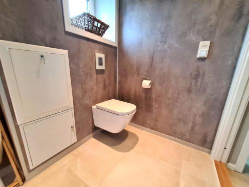 a bathroom with a white toilet in a room at Aurora Central Premium Apartment, Bodø in Bodø