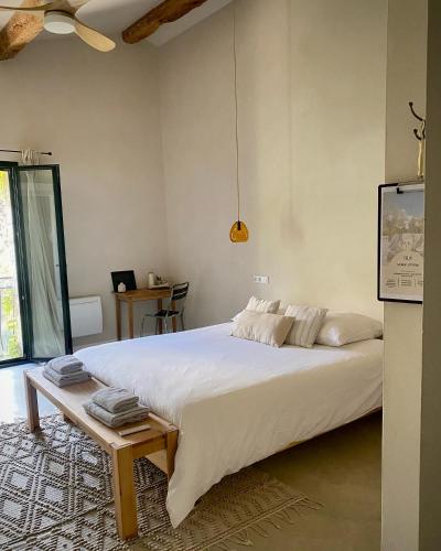 a bedroom with a large white bed and a table at Felix - Maison d'hôtes in Néffiès