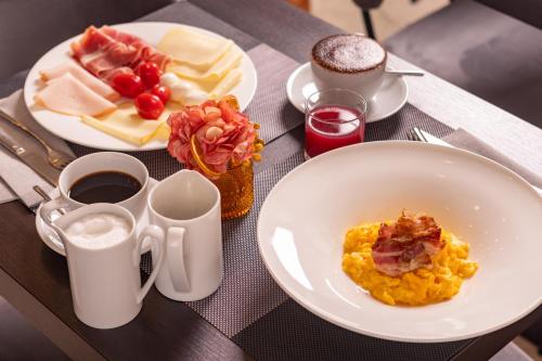 a table with two plates of breakfast food and coffee at Hotel Royal Falcone in Monza