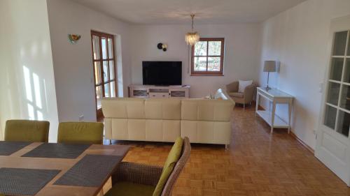 a living room with a television and a table and chairs at Ferienwohnung Dirscherl in Tiefenbach