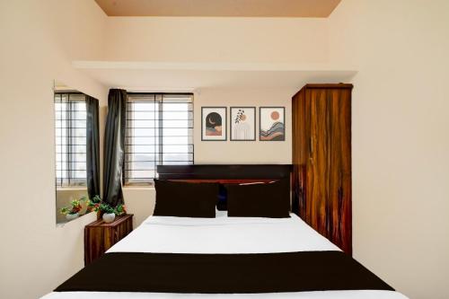 a bedroom with a black and white bed and windows at Hotel O Blue Petals in Hyderabad