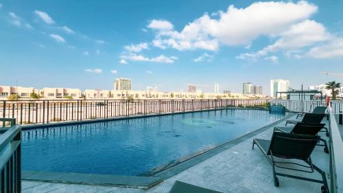 a large swimming pool on a building with chairs at Legacy by Sunrise - Top Amenities and Paddle Court in Dubai