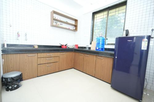 a kitchen with a black refrigerator and wooden cabinets at Newly Built Spacious and luxurious 4BHK apartment in Tirupati with Fully Functional Kitchen, Wifi, and Ample space for car Parking in Tirupati