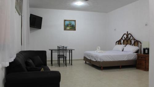 a bedroom with a bed and a table and a chair at Hotel Hacienda Margot in Valladolid
