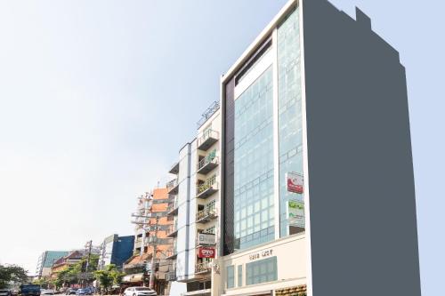 a tall glass building on a city street at Orange Nest Hotel in Manila