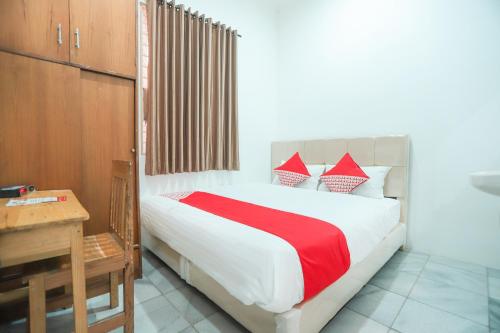 a bedroom with a bed with red and white pillows at Hotel O near Bundaran HI formerly Harmoni Residence in Jakarta