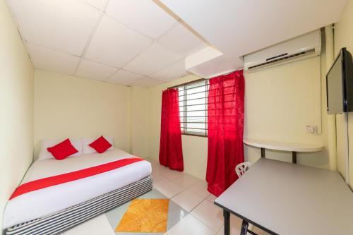 a bedroom with a bed and a table and a window at Hotel O My 7days Inn in Johor Bahru