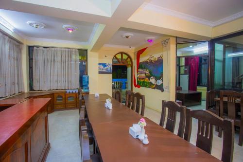 a restaurant with a long table and chairs at OYO 232 Hotel Titanic Pvt Ltd in Bālāju