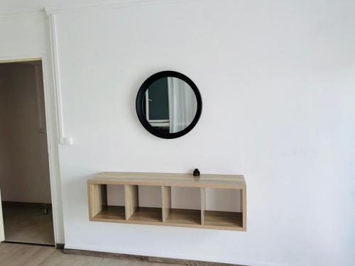 a mirror on a white wall with a wooden table at LaKaz à Eva in Cilaos