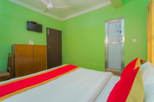 a green bedroom with a bed and a window at Waling Fulbari Guest House in Bālāju